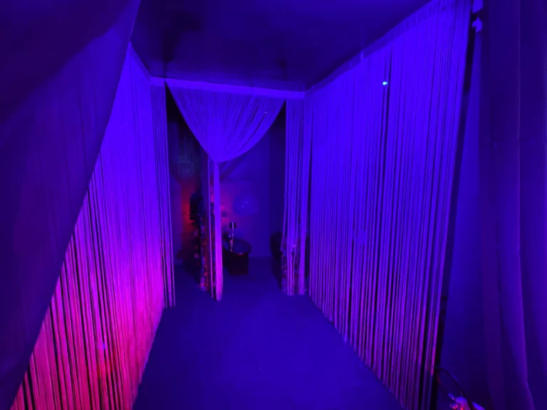 Passaggio di design illuminato con luci neon viola verso l'area riservata del Piper Club, punto di riferimento per la vita notturna a Macerata e provincia.